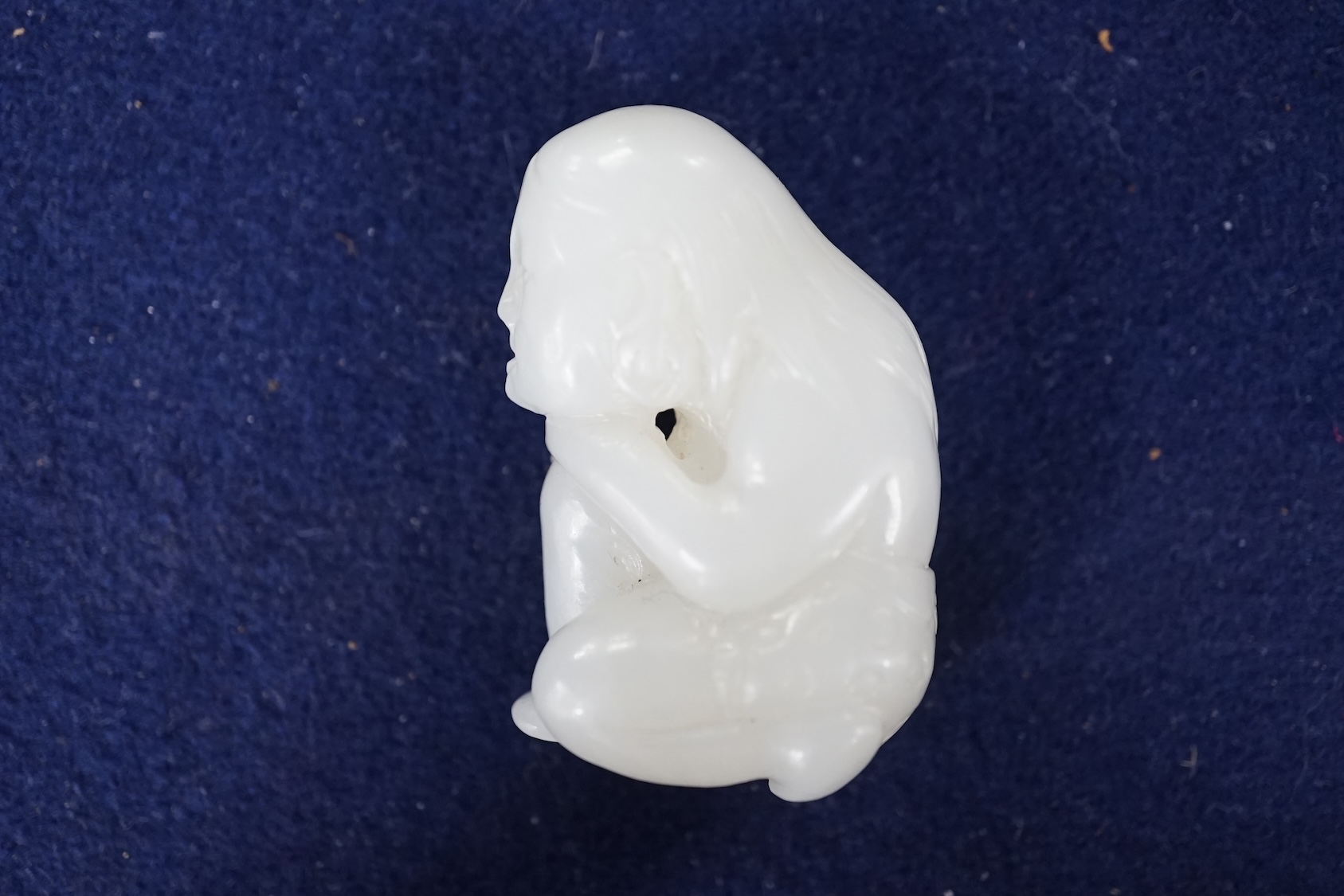 A Chinese white jade carving of a crouching figure, 4.5cm high. Condition - good